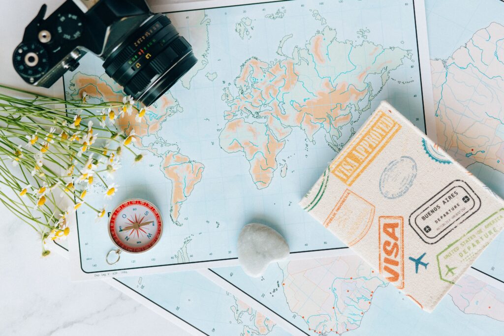 Hộ chiếu đóng dấu visa thông hành đặt trên bản đồ thế giới chuẩn bị cho chuyến đi các tuyến khó năm 2026.