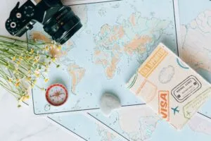 Hộ chiếu đóng dấu visa thông hành đặt trên bản đồ thế giới chuẩn bị cho chuyến đi các tuyến khó năm 2026.