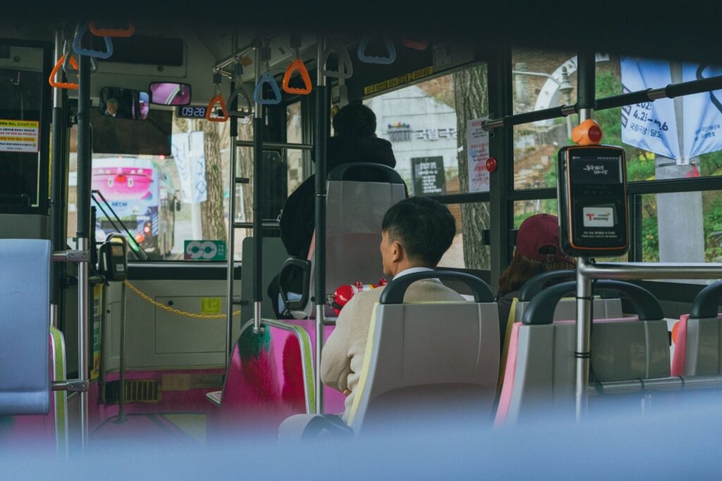 Hành khách trên xe buýt công cộng tại Hàn Quốc và máy đọc thẻ T-money được lắp đặt ngay lối đi.